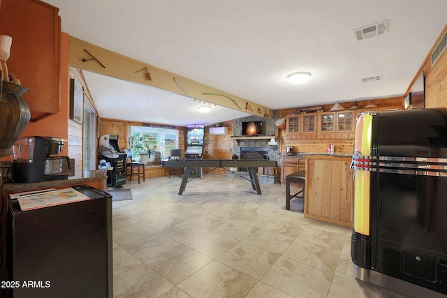 kitchen featuring a fireplace, light tile patterned flooring, and wooden walls