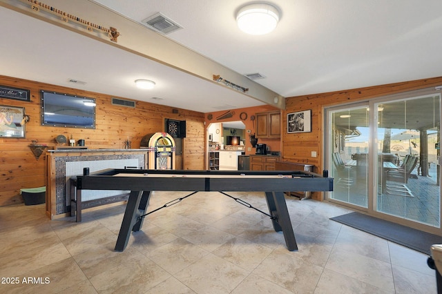 recreation room featuring plenty of natural light and wood walls