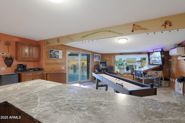 kitchen featuring lofted ceiling and wood walls