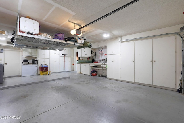 garage featuring washer / clothes dryer, a garage door opener, and a workshop area