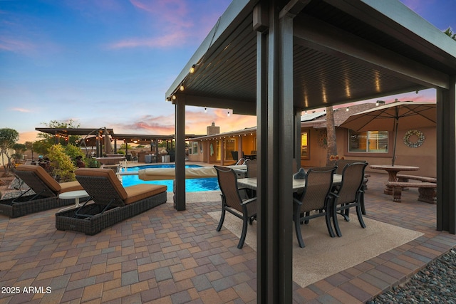 pool at dusk with a patio area