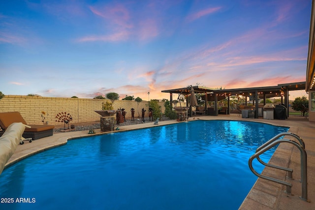 pool at dusk featuring a patio