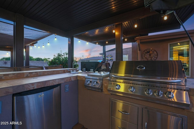 patio terrace at dusk featuring grilling area, area for grilling, and sink