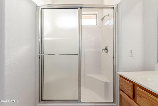 bathroom featuring vanity and a shower with door