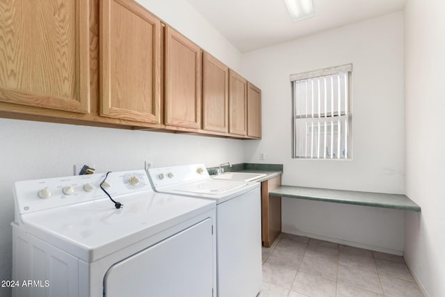 laundry room with washing machine and dryer, sink, light tile patterned flooring, and cabinets