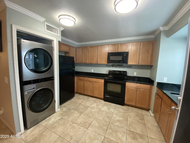 kitchen featuring black appliances, stacked washer and clothes dryer, crown molding, dark countertops, and light tile patterned flooring