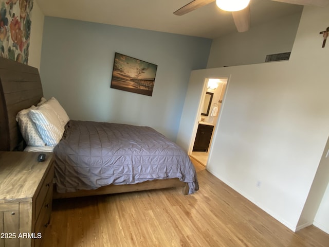bedroom featuring light wood-type flooring, vaulted ceiling, and baseboards