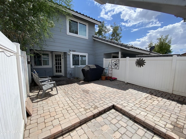 view of patio with fence and a grill