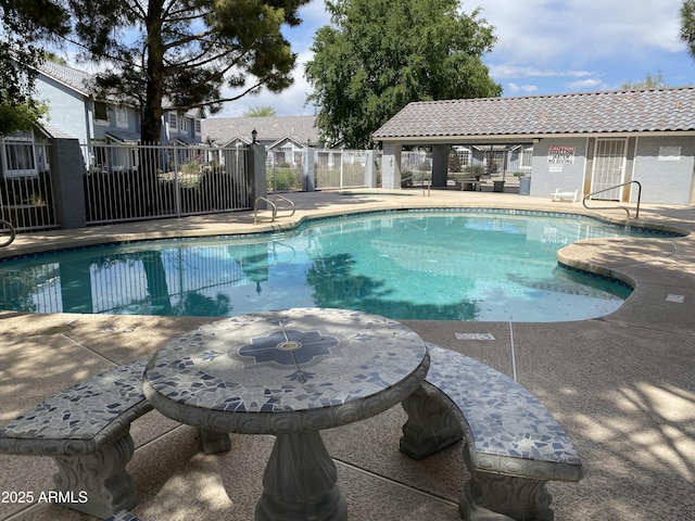 community pool featuring fence and a patio