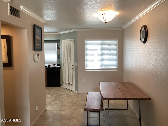 dining area featuring crown molding, light tile patterned flooring, baseboards, and a textured ceiling