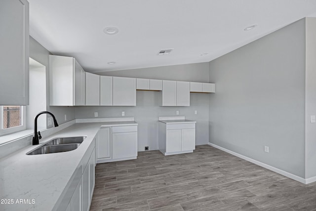 1804 E Pueblo Ave, Phoenix, AZ 85040 - kitchen with a sink, lofted ceiling, white cabinetry, light wood-type flooring, and recessed lighting