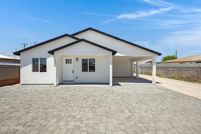 1804 E Pueblo Ave, Phoenix, AZ 85040 - back of house with stucco siding, a carport, decorative driveway, and a patio area