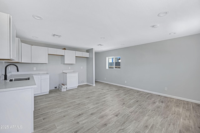1804 E Pueblo Ave, Phoenix, AZ 85040 - kitchen with a sink, light wood-style floors, white cabinets, and recessed lighting