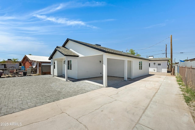 1804 E Pueblo Ave, Phoenix, AZ 85040 - back of property featuring stucco siding, a patio area, driveway, and a shingled roof