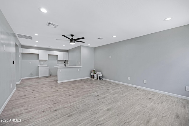 1804 E Pueblo Ave, Phoenix, AZ 85040 - unfurnished living room with a ceiling fan, recessed lighting, baseboards, light wood finished floors, and a sink