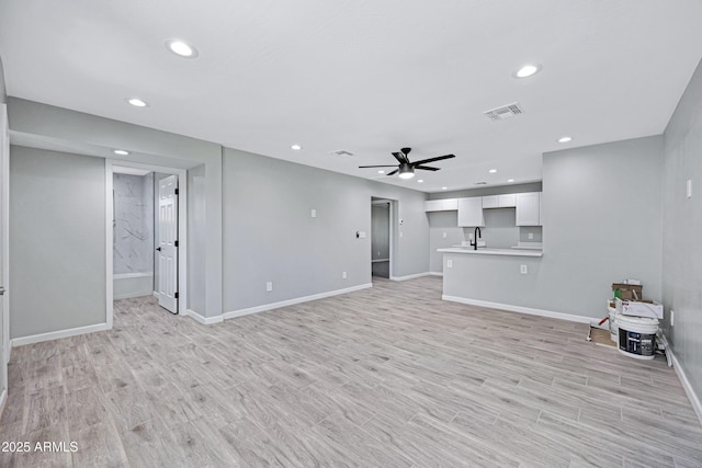 1804 E Pueblo Ave, Phoenix, AZ 85040 - unfurnished living room with recessed lighting, ceiling fan, baseboards, light wood-style floors, and a sink