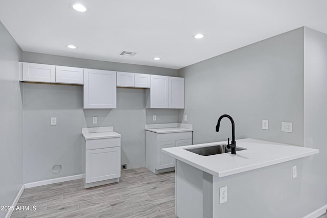 1804 E Pueblo Ave, Phoenix, AZ 85040 - kitchen with a sink, recessed lighting, a peninsula, white cabinets, and light wood-style flooring