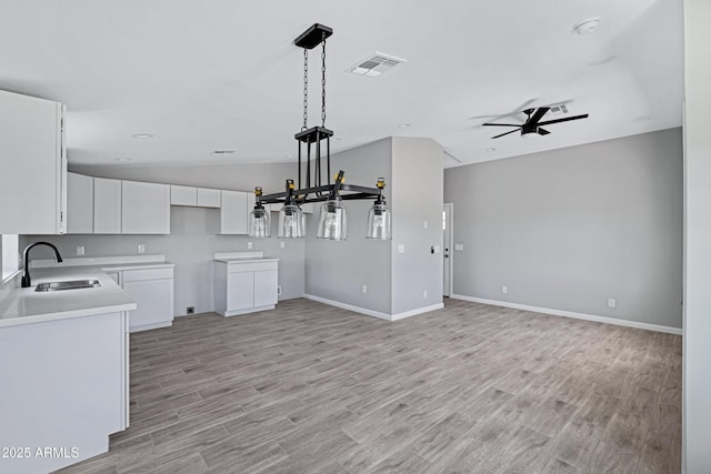 1804 E Pueblo Ave, Phoenix, AZ 85040 - kitchen featuring a sink, a ceiling fan, white cabinetry, light wood-style flooring, and lofted ceiling