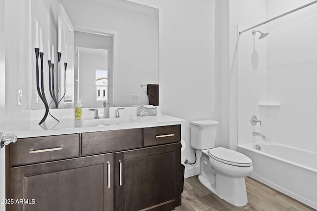 full bathroom with hardwood / wood-style flooring, vanity, tub / shower combination, and toilet