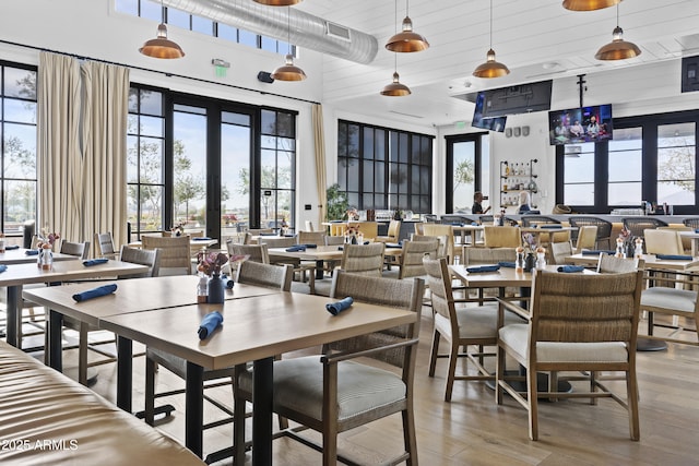 dining space with plenty of natural light, a high ceiling, and light wood-type flooring