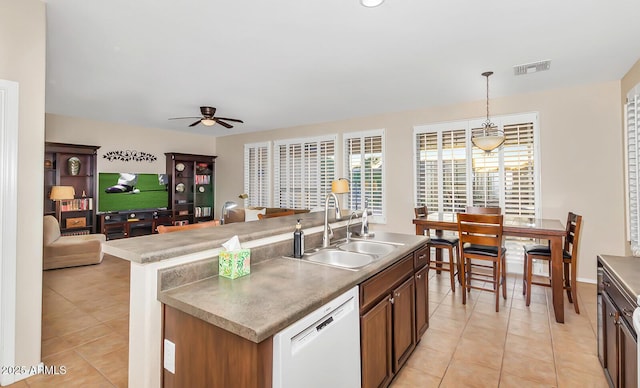 kitchen with a sink, dishwasher, light tile patterned floors, decorative light fixtures, and ceiling fan