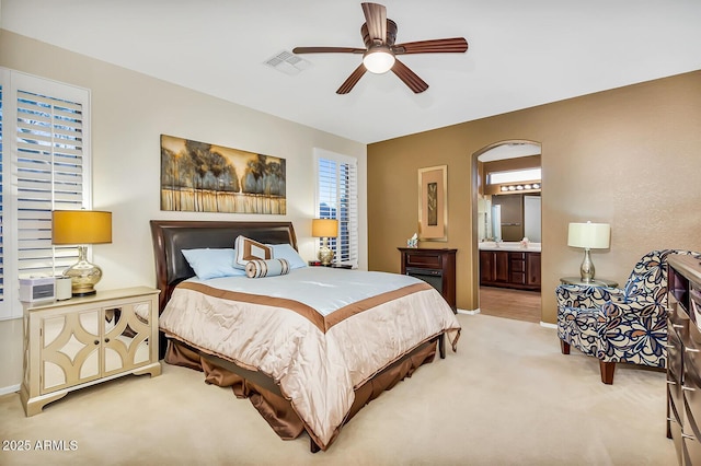 bedroom with carpet floors, baseboards, connected bathroom, and a ceiling fan