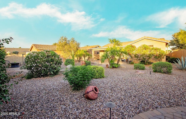 view of property hidden behind natural elements featuring stucco siding, a patio area, and fence