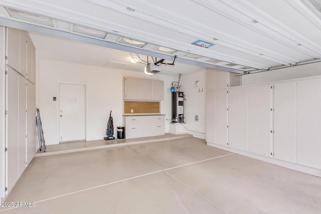 garage with water heater and a garage door opener