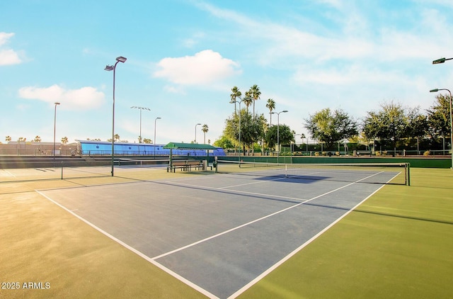 view of tennis court featuring fence