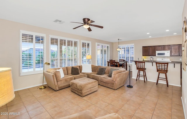 living room featuring plenty of natural light, ceiling fan, light tile patterned floors, baseboards, and recessed lighting