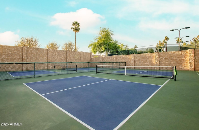 view of tennis court featuring fence and community basketball court