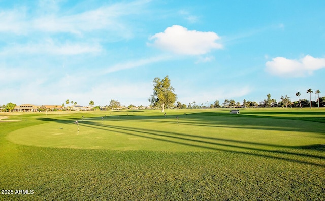 view of property's community featuring a putting green, view of golf course, and a lawn