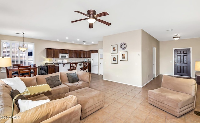 living room with a ceiling fan, light tile patterned flooring, baseboards, recessed lighting, and beverage cooler