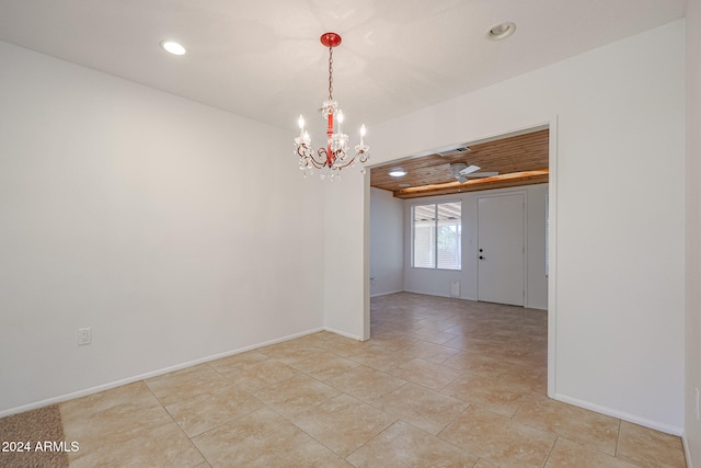 empty room featuring a chandelier and light tile patterned floors