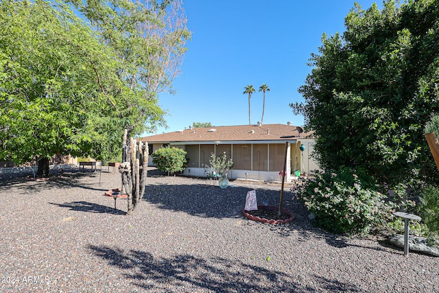 rear view of property featuring a sunroom