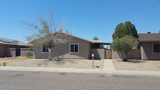 view of front of house featuring a gate, stucco siding, and fence