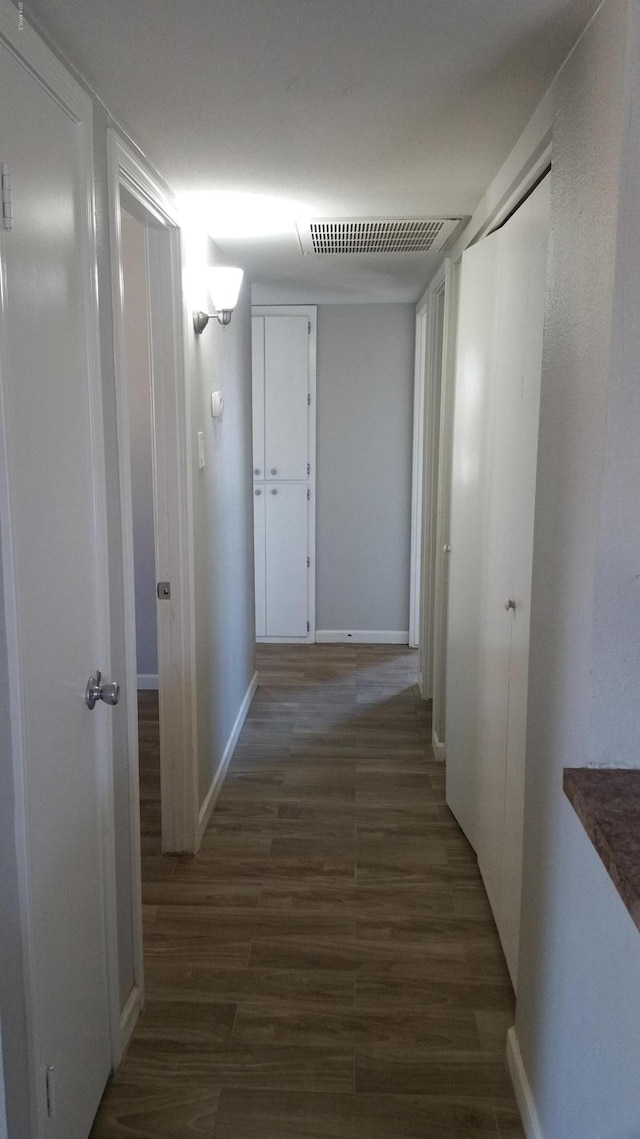 corridor with wood finished floors and baseboards