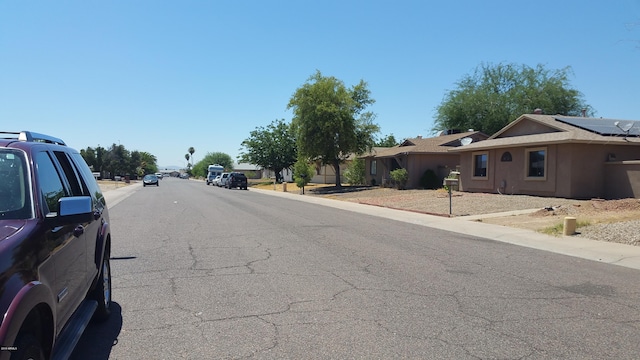 view of asphalt street featuring curbs