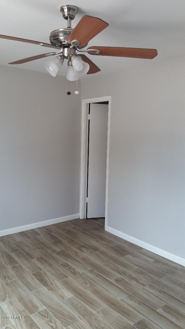 unfurnished room featuring a ceiling fan, light wood-style floors, and baseboards