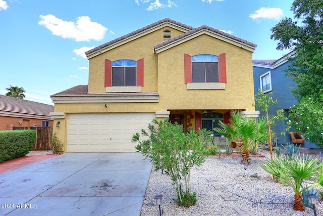 view of front of home with a tile roof, concrete driveway, a garage, and stucco siding