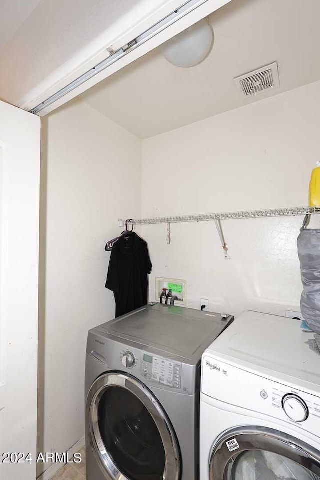 laundry room with visible vents, washing machine and dryer, and laundry area