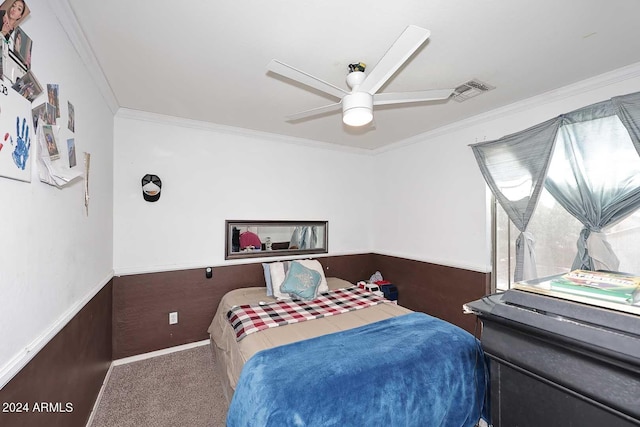 carpeted bedroom featuring ceiling fan, a wainscoted wall, and ornamental molding