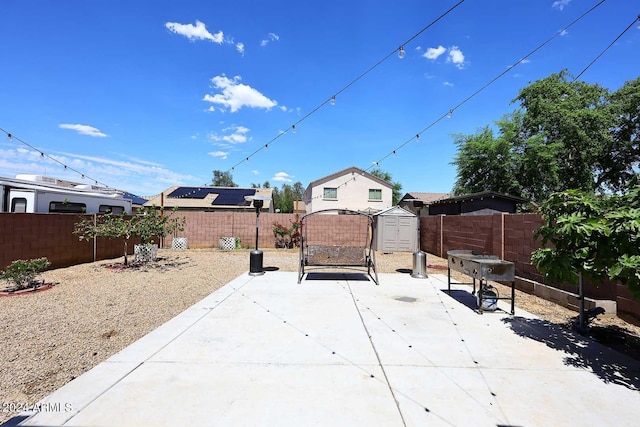 view of patio featuring a storage shed, an outbuilding, and a fenced backyard