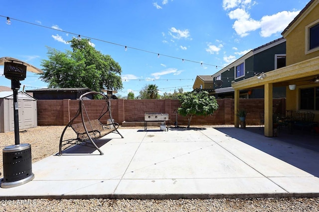 view of patio featuring a storage unit, an outdoor structure, and a fenced backyard