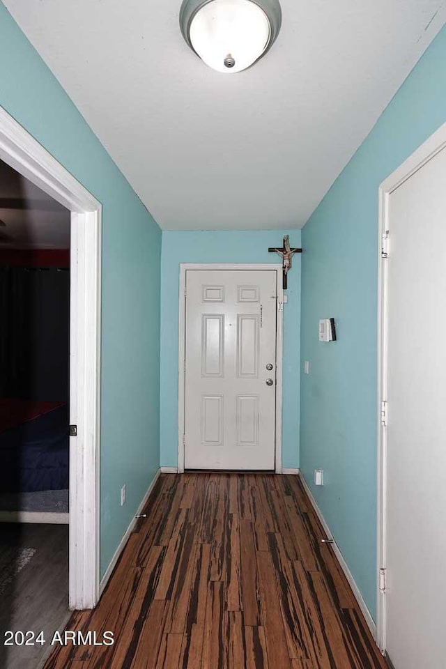 entryway featuring baseboards and wood finished floors