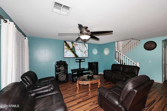 living area featuring stairs, wood finished floors, visible vents, and a ceiling fan