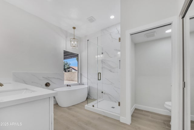 3926 E Coconino St, Phoenix, AZ 85044 - bathroom featuring a marble finish shower, a freestanding bath, wood finished floors, vanity, and recessed lighting