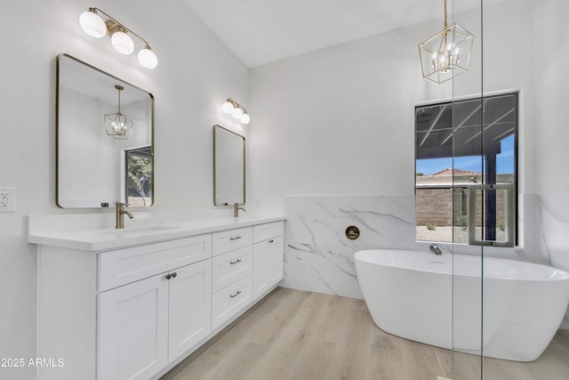 3926 E Coconino St, Phoenix, AZ 85044 - full bathroom with a chandelier, double vanity, a soaking tub, and wood finished floors