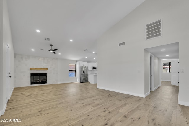 3926 E Coconino St, Phoenix, AZ 85044 - unfurnished living room featuring ceiling fan, light wood-type flooring, recessed lighting, a high ceiling, and a large fireplace