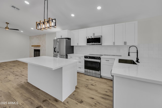 3926 E Coconino St, Phoenix, AZ 85044 - kitchen featuring appliances with stainless steel finishes, decorative backsplash, recessed lighting, white cabinetry, and hanging light fixtures